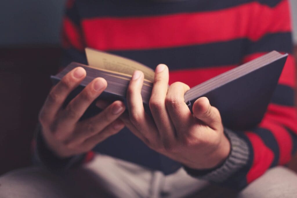 A person holding a wallet and looking at his cell phone.