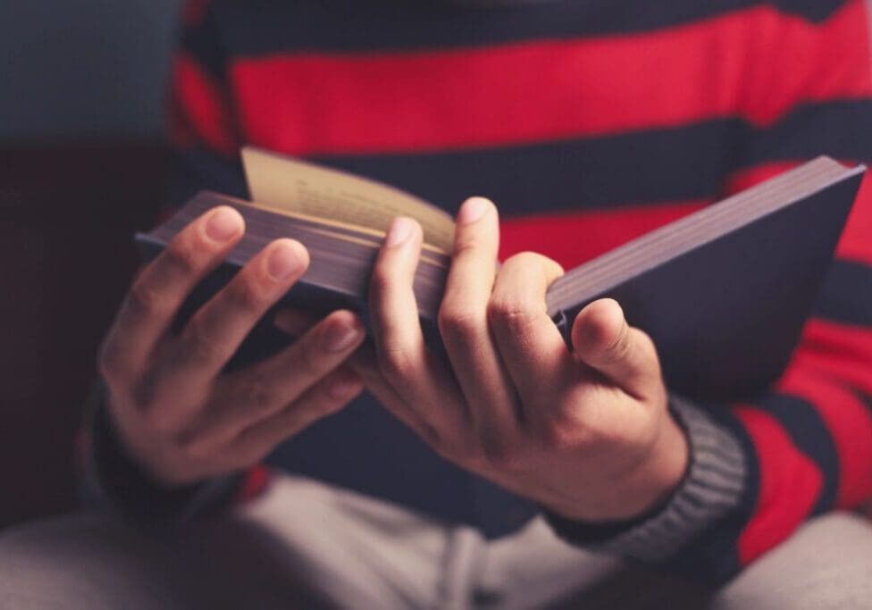 A person holding a wallet and looking at his cell phone.